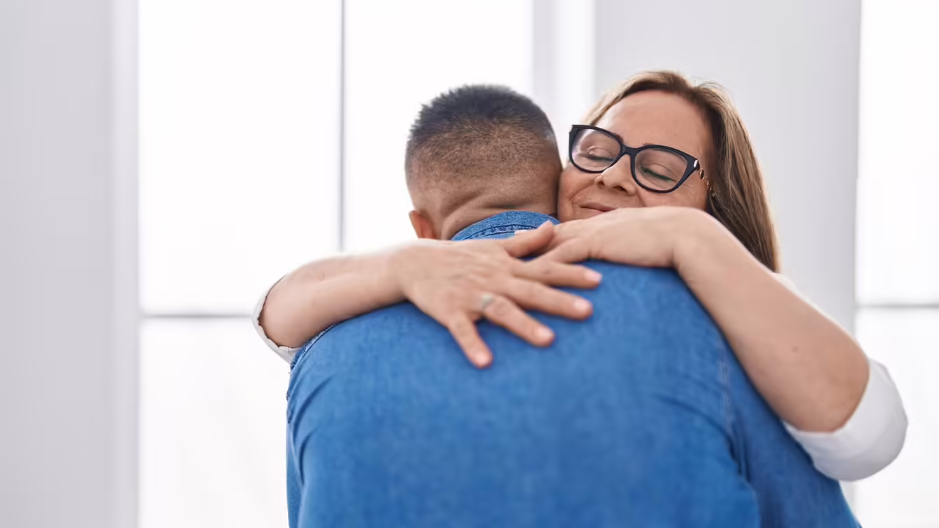 Mother hugging her adult son who is struggling with mental health issues