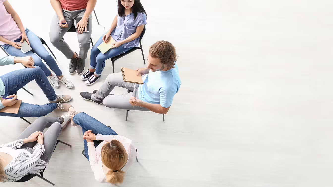 Aerial view of coed rehab therapy group during your first day at a mental health php