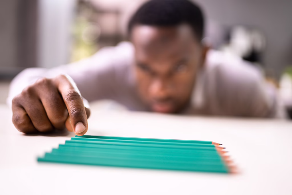 man arranging pencils in a specific formation exhibiting signs of OCD